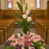 Pink lilies and roses arranged in a church setting