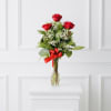Red roses in a clear glass vase with a red ribbon