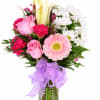 Pink and white mixed bouquet in a glass vase with a purple ribbon