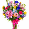 Colorful mixed bouquet in a clear glass vase with a pink ribbon