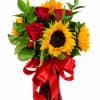 Bouquet of red roses and yellow sunflowers in a glass vase with a red ribbon