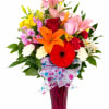 Colorful bouquet of lilies, roses, gerbera daisies, and carnations in a pink vase