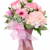 Pink and white bouquet in a textured vase with a pink ribbon