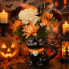 Halloween flower arrangement in a black cat vase with orange and white blooms