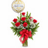 Red roses in a glass vase with a gold anniversary balloon