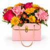 Pink and yellow mixed bouquet in a pink gift box with a gold chain handle