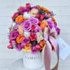 Mixed bouquet of pink, purple, and orange roses in a white hat box with ribbon