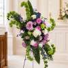 Tall floral spray with purple, white, and green blooms on a stand
