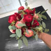 Handheld bouquet of red and pink flowers with eucalyptus foliage