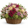 Mixed pink and cream flower arrangement in a wicker basket