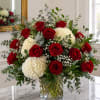 Red roses and white hydrangeas in a clear glass vase