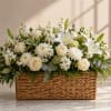 White roses and lilies arranged in a woven basket