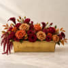 Red and orange roses arranged in a gold rectangular container