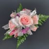 Pink rose corsage with silver ribbon and green fern accents