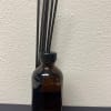 Amber glass bottle with black reed sticks