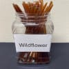 Clear jar filled with brown sticks labeled Wildflower