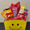 Candy assortment in a yellow smiley-face gift box