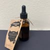 Amber dropper bottle labeled beard oil with a hanging tag