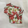 Wisconsin-shaped design filled with red berries and green leaves