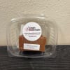 Plastic clamshell container holding a block of milk chocolate fudge