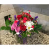 Mixed bouquet of red, pink, and white flowers in a glass vase