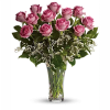 Pink roses arranged in a clear glass vase with white filler flowers