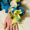 Creamy white Asiatic lilies and soft spray roses form a luminous wrist