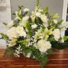 White floral arrangement with lilies, chrysanthemums, and carnations in a basket