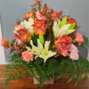 A sunlit spray of orange roses and creamy white lilies makes a
