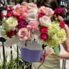 Large bouquet of pink, white, and lime flowers in a lavender box
