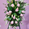 Standing floral spray with pink roses and white blooms on an easel