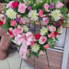 Heart-shaped floral wreath on a stand with pink and white flowers