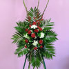 Standing floral spray with red and white flowers and palm fronds