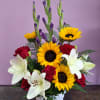 Basket arrangement with red roses, white lilies, and yellow sunflowers