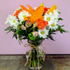 Orange lilies and daisies in a glass vase with twine