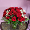 Red roses and white baby's breath arranged in a clear glass vase