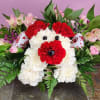 Dog-shaped floral arrangement made of red and white carnations with pink flowers around it