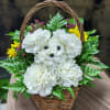 White carnations arranged in a wicker basket with yellow and purple accents