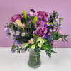 Purple and pink mixed bouquet in a clear glass vase