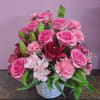 Pink roses and lilies arranged in a white basket