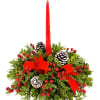 Red taper candle in a holiday greenery arrangement with pinecones and berries