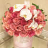 Pink and peach roses with white orchids in a pink hat box