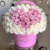 Pink and white roses arranged in a round pink hat box