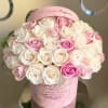 Pink and white roses arranged in a pink hatbox