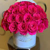 Hot pink roses arranged in a white hatbox