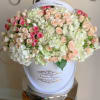 Large bouquet of pink and cream roses in a white hatbox