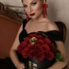 Woman holding a bouquet of red roses in a black box