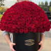 Man holding a large black box filled with red roses