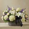 Basket arrangement of white lilies, cream roses, and purple flowers