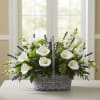 Basket arrangement of white calla lilies and purple flowers